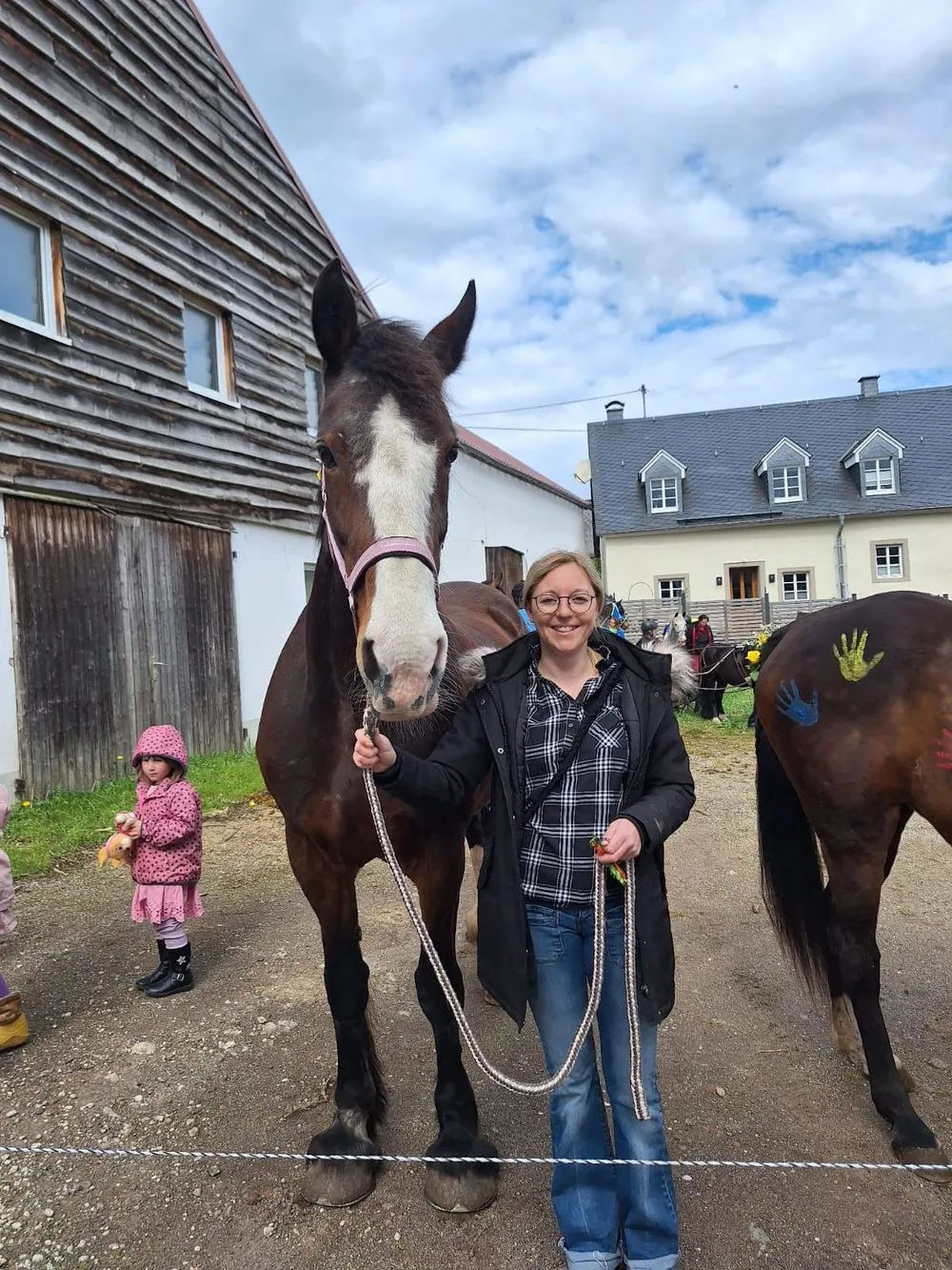 Janis Darev mit zwei Pferden vor dem Hof